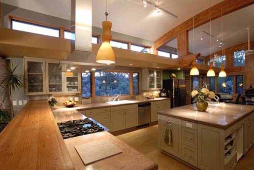 A kitchen with poured earth counters and a light shelf above the southern kitchen windows